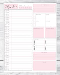 the daily planner is shown in pink and white, on a wooden surface with wood planks