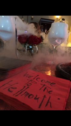 a red napkin sitting on top of a table next to a glass filled with liquid