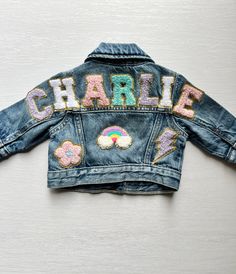 Our custom denim jackets for kids have the name of your choice sewn on the upper back panel of the jacket in chenille letter patches. These personalized jean jackets have additional chenille patches that are sewn on the back, sleeves and front. These name jackets for girls make the perfect customized gift for babies, toddlers and girls! **GAP brand denim jackets in a medium/light wash are used unless specifically stated in the size choice drop down menu. We will substitute with a light wash Old Patch Jean Jacket, Patch Denim Jacket, Jean Jacket Patches, Chenille Patches, Gap Brand, Patch Denim, Jean Jacket For Girls, Letter Patches