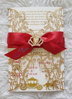 the wedding card is decorated with gold and red ribbon, along with a heart - shaped brooch