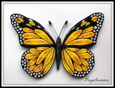 a yellow and black butterfly with white dots on it's wings, sitting in a square frame