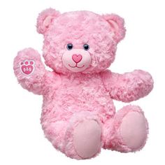 a pink teddy bear sitting up against a white background