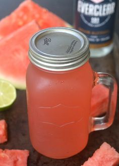 a mason jar filled with watermelon sits next to slices of watermelon