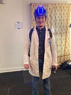 a man wearing a blue helmet standing in a room