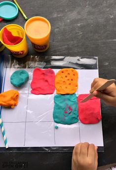 a child is painting cookies on paper with colored icing and watercolors in front of them