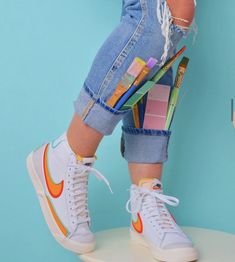 a person standing on top of a white stool with pencils and markers in their shoes