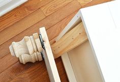 a close up of a drawer on the floor next to a wooden door handle and cabinet