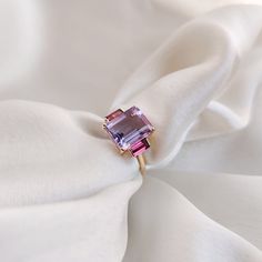 This stunning ring is set in 14k Solid Yellow Gold with Natural Pink Amethyst & Rhodolite Garnet with utmost precision. It is an unique statement gemstone ring for nearly every occasion and is completely hassle-free jewelry. ITEM DETAILS * CENTER GEM: Pink Amethyst  * GEM SIZE: 8X10mm * GEM SHAPE: Octagon (Emerald Cut) * SIDE GEM: Rhodolite Garnet * GEM SIZE: 2.5x5mm (2pc) * GEM SHAPE: Baguette * Gem Weight: 3.65 carats * Gold Purity: 14KT * Gold Weight: 1.61 gram * Total Weight of the Ring: 2.34 gram The Gold purity is guaranteed and it comes with authentic 14KT gold hallmark. Since my items are handmade, they are absolutely nickel and lead free. CUSTOMIZATION * Gemstone customization is available, it can be substituted with a gem of your choice. Kindly drop me a message for the same! PAC Amethyst And Garnet, February Birthstone Ring, Rhodolite Garnet Ring, Handmade Jewelry Box, Garnet Gem, Gold Gemstone Ring, Higher Consciousness, Amethyst Gem, Garnet Ring