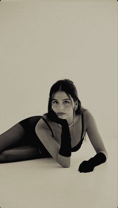 black and white photograph of a woman laying on the floor with her hand under her chin