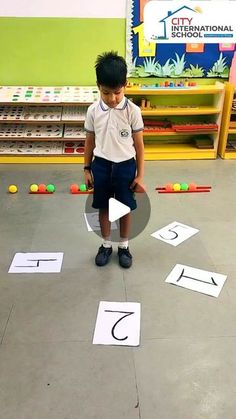 a young boy standing in front of numbers on the floor