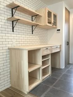 an empty room with some shelves on the wall and tile flooring in front of it