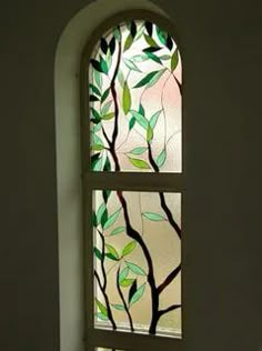 a stained glass window with green leaves on it