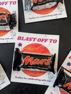 several packets of mars candy sitting on top of a black table next to each other