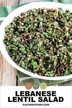 a white bowl filled with lentils on top of a wooden table next to a green napkin