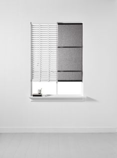 an empty room with white walls and grey blinds