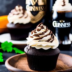 two cupcakes with white frosting and chocolate icing on a wooden plate