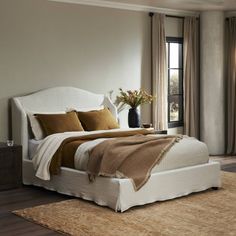 a bedroom with a large bed and wooden floors