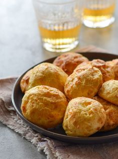 a plate full of biscuits next to two glasses