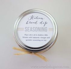 a jar of seasoning sitting on top of a white table next to a yellow ribbon