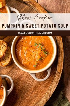 slow cooker pumpkin and sweet potato soup on a wooden platter with two pieces of bread