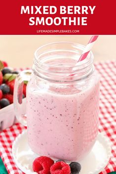 a smoothie in a mason jar with strawberries and raspberries on the side