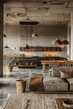 a living room filled with furniture and lots of lights hanging from the ceiling next to an open kitchen