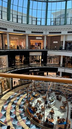 the inside of a shopping mall filled with lots of furniture and people walking around it