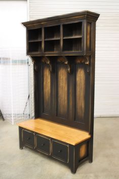 a wooden bench sitting next to a wall with storage cabinets on it's sides