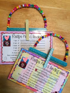 two pieces of paper with beads and writing on them sitting next to each other in front of a wooden table