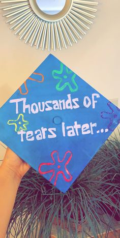 a blue graduation cap that says, thousands of tears later