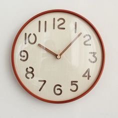 a clock that is on the wall and has numbers painted all over it's face