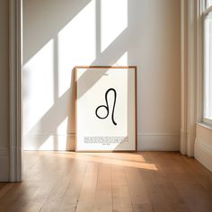 an image of a framed art piece on the floor in front of a window with sunlight streaming through it