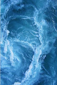 an aerial view of the ocean waves and foamy blue water with white foam on it