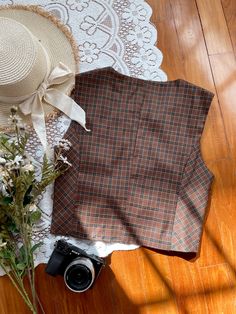 Vintage inspired plaid button up vest with two little side pockets. Lined. S: 32" chest, 16" lengthM: 33.5" chest, 16" lengthL: 35" chest, 16" length Brown Cotton Vest With Buttons, Brown Cotton Vest For Fall, Brown Fall Vest With Pockets, Fall Brown Vest With Pockets, Plaid Vest For Fall, Brown Vest With Pockets For Fall, Plaid Sleeveless Vest For Fall, Classic Brown Vest Top, Casual Brown Vest With Button Closure