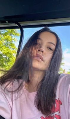 a woman sitting in the back seat of a car with her head out the window