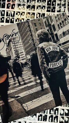 the back of a person's jacket with graffiti on it and people walking in the background