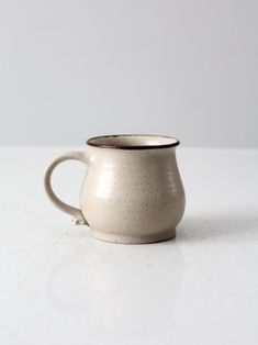 a white coffee cup sitting on top of a table