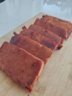 five pieces of food sitting on top of a wooden cutting board