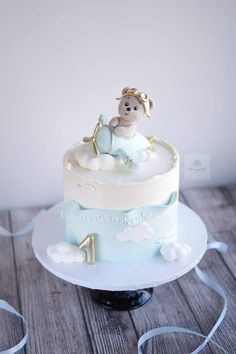 a blue and white cake sitting on top of a wooden table next to a string