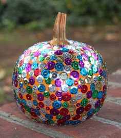 a colorful pumpkin sitting on top of a brick floor