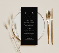 a black and white menu card sitting on top of a plate next to silverware