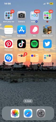 an iphone screen with icons on it and the sun setting in the backgroud