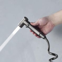 a person is holding an object with a hose attached to the handle and it's spewing out