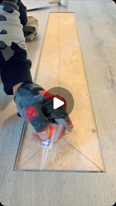 a person using a drill to install a wooden floor