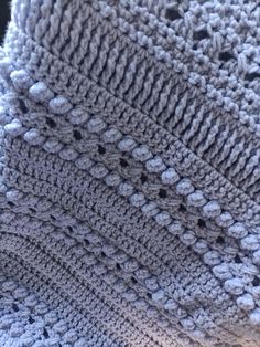 a crocheted blanket sitting on top of a wooden table