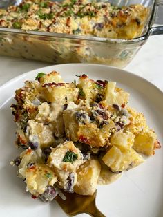 a white plate topped with food next to a casserole dish