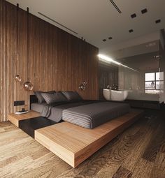 a large bed sitting on top of a wooden floor next to a bathtub in a bathroom