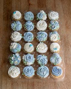 cupcakes with frosting and blue flowers on a tray