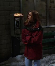 a woman standing in front of a phone booth