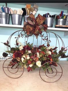 a metal carriage with flowers and leaves on it